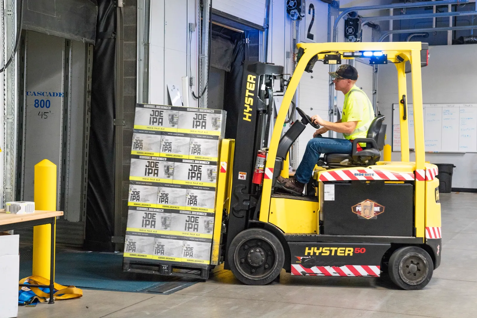 Used Hyster 50 forklift loading pallets at a warehouse dock, for sale in the DC metro